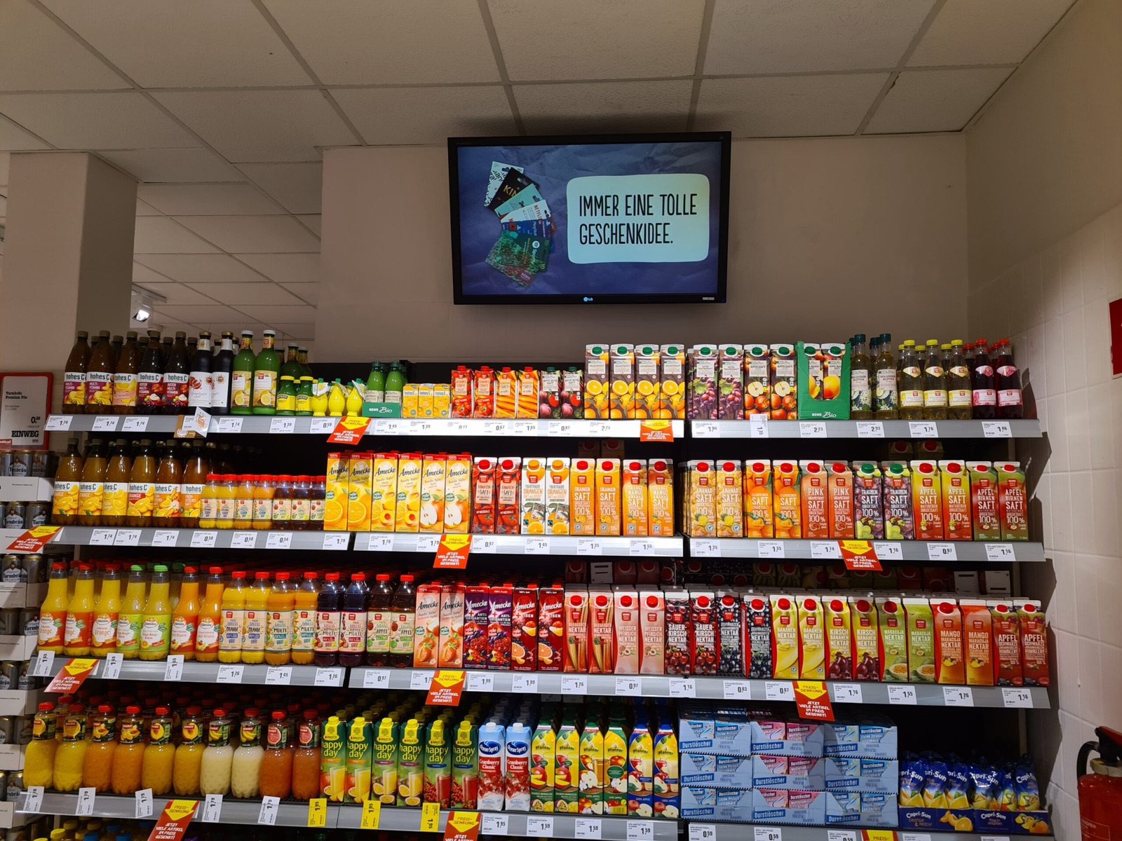Werbemonitor über dem Getränkeregal